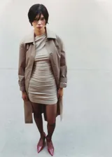 Vestido corto de diseño entallado con escote asimétrico y manga corta en un solo lado. Presenta un acabado con detalles fruncidos en toda la prenda y tejido elástico.