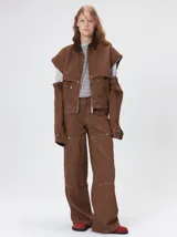 Campera de denim a rayas verticales con cuello de pana en color bordó. Presenta cierre frontal, mangas desmontables con cierre en los hombros, canesú en el pecho y bolsillos de parche cuadrados.