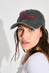 Gorra de gabardina negra con efecto lavado vintage, logo bordado en rojo en el frente y corazón bordado en la parte trasera.