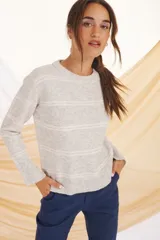 Sweater de punto gris claro con rayas horizontales blancas.