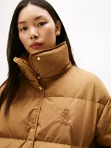 Campera acolchada de corte regular con cuello chimenea, cierre frontal a presión con botones dorados y hombros caídos. Presenta un diseño repelente al agua con relleno de plumas.