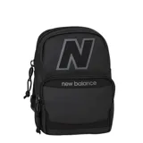 Bandolera tipo mochila pequeña New Balance, color negro, con cierre frontal y compartimento principal. Presenta el logo 'N' grande en la parte superior y el nombre de la marca en el bolsillo delantero.