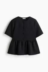 Top negro de manga corta en tejido efecto neopreno, con escote redondo, botones forrados en el frente y detalle de peplum en la parte inferior.