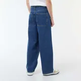 Pantalón de jean con corte baggy, de tiro medio y pierna ancha, en color azul clásico con costuras a tono.