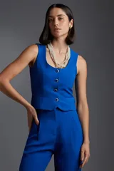 Pantalón de vestir color arena, de corte palazzo, con bolsillos laterales y cinturón con hebilla dorada.