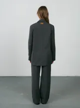 Blazer negro de lana con rayas verticales finas, corte clásico, solapas de muesca y cierre con botones.