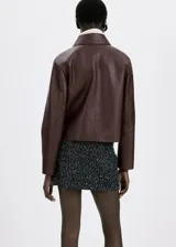 Chaqueta de cuero sintético marrón con cuello camisero, cierre frontal de botones oscuros y bolsillos frontales de parche con solapa.