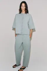 Pantalón de tiro medio confeccionado en hilatura con mezcla de algodón, con diseño de rayas diplomáticas. Presenta bolsillos laterales ocultos en costura, pierna ancha y cierre frontal con cremallera y botón.