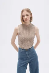 Chaleco verde pálido de punto con cuello alto y diseño trenzado.