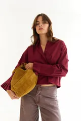 Camisa de corte boxy en color blanco, con cuello clásico, cierre frontal de botones y mangas largas con puños estructurados con tablas. Presenta costuras a contratono y detalle de frunce en la espalda.