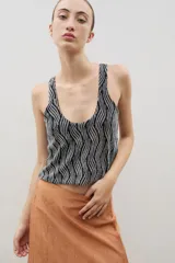 Top de escote redondo y diseño sin mangas, confeccionado en tejido con textura brillante y estampado abstracto de líneas verticales en tonos negro y plateado.