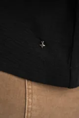 Blusa negra de manga corta y cuello redondo, confeccionada en tejido ligero y fluido.