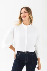 Camisa blanca de mangas 3/4 abullonadas, cuello mao y cierre frontal con botones.