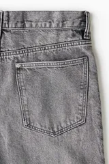 Bermuda de cinco bolsillos en denim de algodón rígido, con corte holgado, pierna amplia y tiro caído.