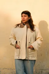 Chaqueta de silueta relajada, confeccionada en paño de lana color verde militar con detalles en pana de algodón marrón en el cuello y los bolsillos. Cuenta con cuello alto, bolsillos frontales amplios y cordón regulable en la cintura.