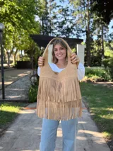 Cartera tipo hobo de cuero color beige con flecos en dos niveles.