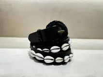 Cinturón negro de cuero vacuno con hebilla forrada en trenza de cuero y caracoles naturales aplicados.