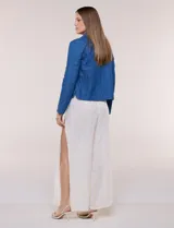 Chaqueta azul de algodón con diseño acolchado y bordado de flores, cuello redondo y cierre frontal con botones a presión metálicos. Incluye bolsillos delanteros y forro interno a tono.