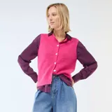 Chaleco sin mangas de punto suave en color fucsia, con escote en V y cierre frontal de botones blancos.