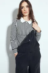 Remera de manga larga a rayas verticales blancas y negras, con cuello polo blanco y cierre frontal de botones. Confeccionada en tejido elástico que se ajusta al cuerpo.