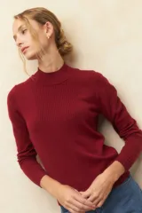 Polera color borgoña de tejido de punto con cuello alto y mangas largas.