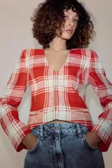 Chaqueta entallada de Zara Woman Collection confeccionada en mezcla de algodón con diseño de cuadros en tonos rojo y crudo. Presenta escote en pico, manga larga, bolsillos de vivo en el delantero y bajo asimétrico con cierre frontal de ganchos metálicos.
