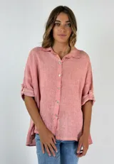 Camisa color salmón de lino con cuello clásico, cierre frontal con botones y mangas 3/4 con trabilla.
