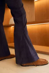 Pantalón de corderoy color beige, tiro alto, corte ajustado en muslos y campana marcada en la parte inferior.