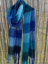 Bufanda larga con flecos, diseño a cuadros en tonos amarillos, naranjas, azules y celestes.