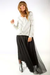 Sweater de punto color blanco con diseño de rayas en zigzag formadas por pequeñas aplicaciones brillantes. Presenta un corte holgado con mangas tipo murciélago y cuello redondo.