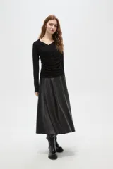 Top de manga larga color negro, confeccionado en poliéster, con diseño drapeado frontal y cuello en V.