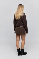 Minifalda de jean negra con silueta recta, tiro medio y bolsillos funcionales delanteros y traseros.