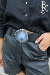 Cinto de cuero azul con hebilla circular de piedra ágata con borde dorado.