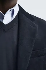 Blazer de corte relajado confeccionado en pana de algodón. Presenta cuello con solapas de muesca, cierre frontal con botones, bolsillo de vivo en el pecho y bolsillos con solapa en la cadera. Incluye aberturas en la espalda y puños con botones.