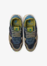 Championes urbanos Satorisan modelo Chacrona, confeccionados en cuero marrón con detalles en gamuza, cordones amarillos y suela de goma con efecto salpicado y detalles en verde.