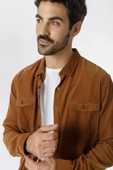 Camisa de pana color azul marino, con mangas largas, cuello clásico y dos bolsillos frontales con solapa y botón.