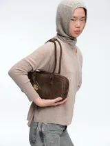 Sweater de corte holgado tipo poncho con cuello en V, mangas largas con puños acanalados y aberturas laterales.