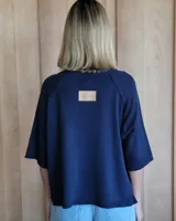 Buzo de punto color verde kiwi con cuello, puños y ruedo en azul.