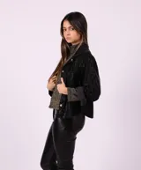 Camisa negra de cuero sintético con botones dorados.