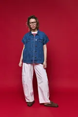 Chaleco de jean oversized color negro, con cuello camisero y cierre frontal con botones metálicos. Presenta un diseño estructurado con costuras reforzadas.