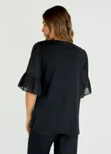 Blusa color beige de corte holgado y mangas cortas con volantes.