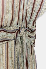 Vestido midi de Zara Woman Collection, con estampado de rayas verticales y detalles ornamentales, escote en V, mangas cortas con aberturas en los hombros, y fajín integrado con lazo lateral del mismo tejido.