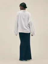 Falda larga color crema, tejida en algodón, con cintura elastizada y detalle de cobre con logo.