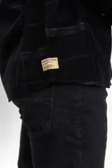 Camisa de pana color azul marino, con mangas largas, cuello clásico y dos bolsillos frontales con solapa y botón.