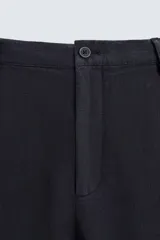 Pantalón de vestir azul marino confeccionado en tejido de lino. Corte recto, con bolsillos laterales y traseros. Se ajusta a la cintura con botón y cremallera.