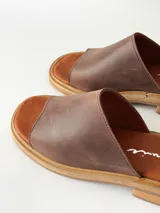 Sandalias de cuero color chocolate, con faja ancha en el empeine, plantilla de gamuza y suela plana con taco bajo.