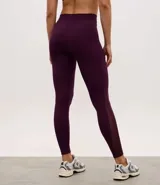 Legging deportiva de tiro alto con cintura ancha, confeccionada en poliamida y elastano. Presenta un diseño ajustado al cuerpo en color violeta oscuro, con costuras reforzadas y acabado liso.