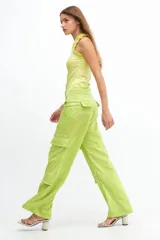 Pantalón cargo color coral de satén, de tiro medio con múltiples bolsillos y calce holgado.