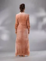 Saco largo tejido de lana Merino natural con diseño jacquard de ramas. Cuenta con cuello alto, cierre frontal con botones pequeños, mangas largas con puños entallados y aberturas laterales. Su diseño versátil permite usarlo abierto, cerrado como vestido o ajustado.