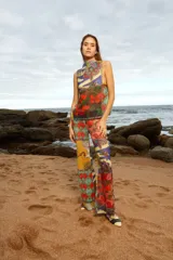 Pantalón de tiro medio con elástico en la cintura y corte acampanado. Diseño con estampado multicolor de patchwork con motivos florales y geométricos.